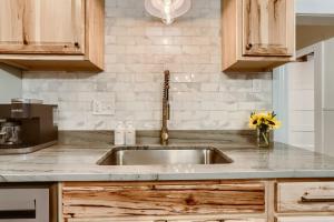 a kitchen with a stainless steel sink and wooden cabinets at A-Lodge Lyons in Lyons