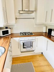 a kitchen with white cabinets and a stove top oven at Skipton Cottage in Skipton