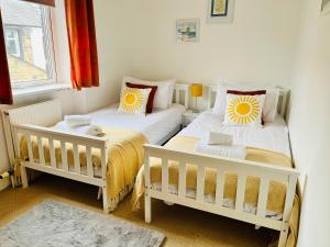 two twin beds in a room with a window at Skipton Cottage in Skipton