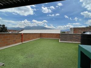 a large backyard with a brick wall and green grass at Housinn co-living Fatima en Medellín in Medellín