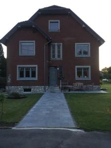 a large red brick house with a pathway in front of it at Haus Dany in Raeren