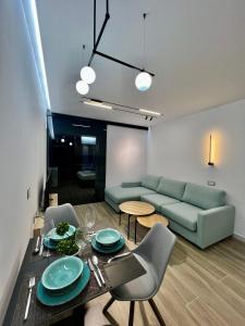 ein Wohnzimmer mit einem Sofa, einem Tisch und Stühlen in der Unterkunft Deluxe apartment bllok in Tirana