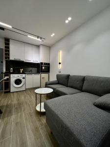 ein Wohnzimmer mit einem Sofa und einer Küche in der Unterkunft Deluxe apartment bllok in Tirana