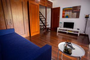 ein Wohnzimmer mit einem blauen Sofa und einem Tisch in der Unterkunft Casa Vereda, Ponta Delgada, S. Miguel in Ponta Delgada