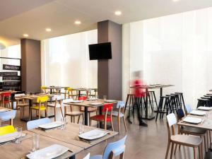 a restaurant with tables and chairs and a tv at Ibis Mexico Tlalnepantla in Mexico City