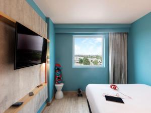 - une chambre avec un grand lit et une fenêtre dans l'établissement ibis budget Aguascalientes Norte, à Aguascalientes