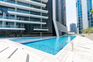 a swimming pool in front of a building at Ultimate Stay / 4 Beds / Burj Khalifa View / Ultra Modern / Business Bay in Dubai