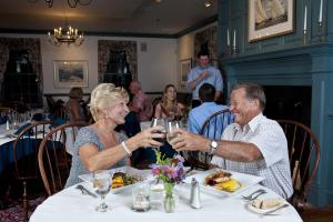 a man and woman sitting at a table with wine glasses at Inn at Osprey Point in Rock Hall