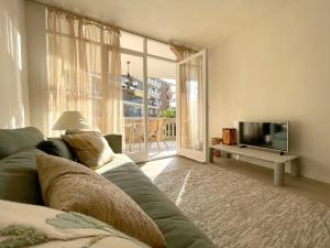 a living room with a couch and a television at Synergie SI01 - Ideal para descansar in Salou