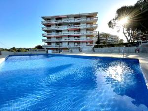 a large blue swimming pool in front of a building at Synergie SI01 - Ideal para descansar in Salou