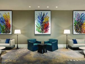 a waiting room with chairs and paintings on the wall at Fairmont Dallas in Dallas