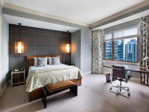 a bedroom with a bed and a chair and a window at Fairmont Chicago Millennium Park in Chicago