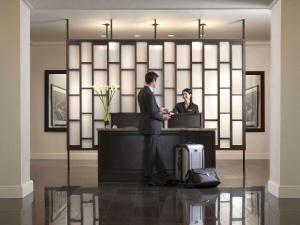 two men standing at a desk in a lobby at Fairmont Palliser in Calgary