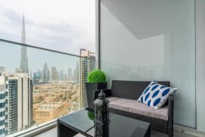 Appartamento dotato di balcone con divano e tavolo. di Ultimate Stay / 4 Beds / Burj Khalifa View / Ultra Modern / Business Bay a Dubai