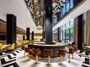 a hotel lobby with a bar with chairs and tables at Fairmont The Queen Elizabeth in Montreal