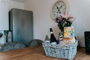 uma cesta de vinho e pão sobre uma mesa com um relógio em Bluebell cottage Branston Lincoln em Branston