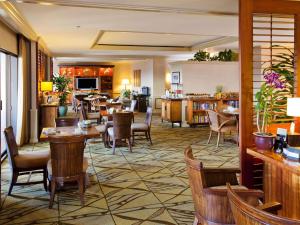 a hotel lobby with tables and chairs and a kitchen at Fairmont Orchid in Waikoloa