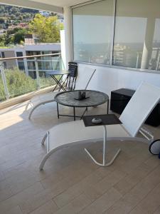 a balcony with two tables and chairs on a building at Grand 3 pièces avec terrasse vue mer tout confort in Beausoleil
