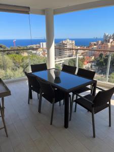 a table and chairs on a balcony with a view of the ocean at Grand 3 pièces avec terrasse vue mer tout confort in Beausoleil