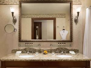 a bathroom with two sinks and a large mirror at Fairmont Château Lake Louise in Lake Louise