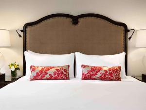 1 cama con 2 almohadas y cabecero grande en Fairmont Château Lake Louise, en Lago Louise