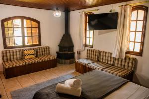 a bedroom with a bed and a fireplace and a tv at Pousada Tapera in Penedo