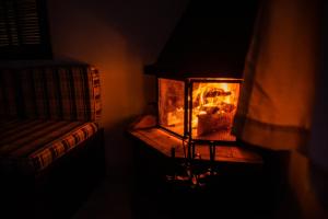 - une cheminée dans une pièce avec un canapé à côté dans l'établissement Pousada Tapera, à Penedo