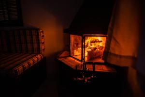 a fireplace in a room with a couch next to it at Pousada Tapera in Penedo