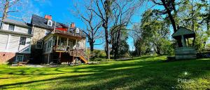 a large house on a lawn with a statue in the yard at Wayside Inn Bed and Breakfast in Ellicott City