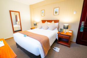 een hotelkamer met een groot bed en een spiegel bij El Tumi Hotel in Huaraz