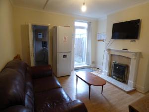 a living room with a couch and a fireplace at Station House in Shirebrook