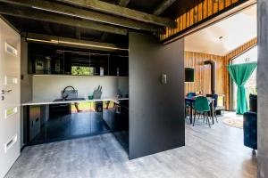 a kitchen with black cabinets and a dining room at ŚwiętySpokój Puszcza in Białowieża
