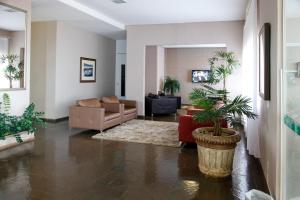 a living room with a couch and palm trees at Attiê Park Hotel in Uberlândia