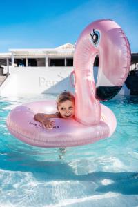 un niño pequeño en una balsa en una piscina en Papagayo Beach Resort, en Willemstad