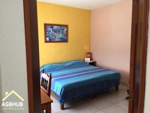 a bedroom with a bed and a picture on the wall at AGBHub Coworking & Rooms in Oaxaca City