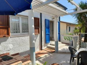 a patio with a blue umbrella and a house at Village SOGNO in Massa