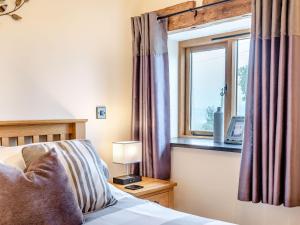 Schlafzimmer mit einem Bett und einem Fenster in der Unterkunft The Granary in Llanfair Caereinion