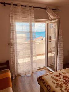 a bedroom with a window with a view of the ocean at Apartment Metajna 527a in Metajna