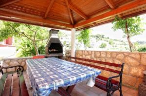 a table and bench on a patio with a fireplace at Apartment Kampor 4972b in Kampor