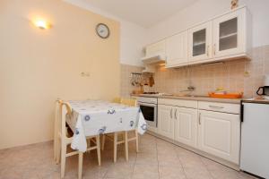 a kitchen with a table and chairs and a sink at Apartment Kampor 4972b in Kampor +23 photos