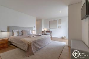 Habitación blanca con cama y sofá en Home Azores - Coliseu Residences en Ponta Delgada