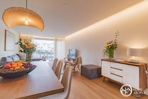 comedor y sala de estar con mesa de madera en Home Azores - Coliseu Residences en Ponta Delgada