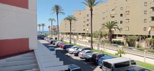 una fila de autos estacionados en un estacionamiento con palmeras en SALOMAR GOLF, en Salobreña