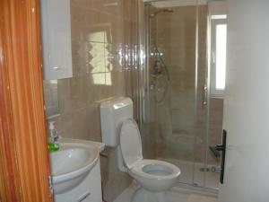 un bagno con wc, doccia e lavandino di Apartments with parking space Kampor, Rab - 4984 a Rab