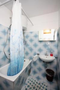 a blue tiled bathroom with a tub and a sink at Apartments with a parking space Kampor, Rab - 4984 in Rab