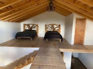- 2 lits dans une chambre dotée de parquet et de plafonds en bois dans l'établissement Cabañas el Pino 3, à Creel