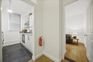 un pasillo que conduce a una cocina con una boca de incendios en Modern Deluxe Apartment London Camberwell Denmark en Londres