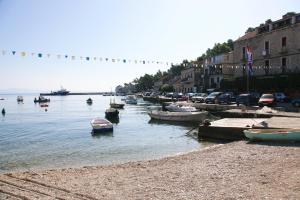 a group of boats in the water next to buildings at Secluded holiday house Prigradica, Korcula - 19956 in Blato +4 photos