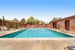 a swimming pool with chairs and a fence at Solano Vallejo 3288 in Moab