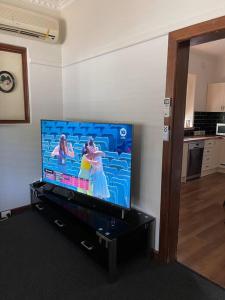 a living room with a flat screen tv on a entertainment center at Classic Beauty in Albury